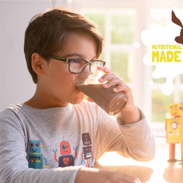 Header Nutritional Desktop Young boy drinking a glass of Nesquik